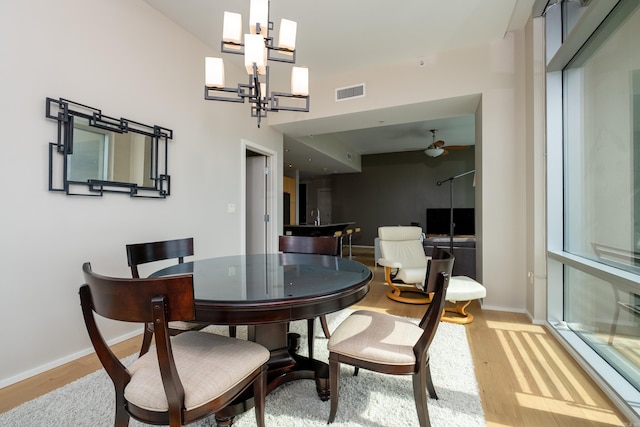300 Third Unit 708, Little Rock, AR 72201 - dining room with light wood finished floors, a chandelier, baseboards, ceiling fan, and a high ceiling