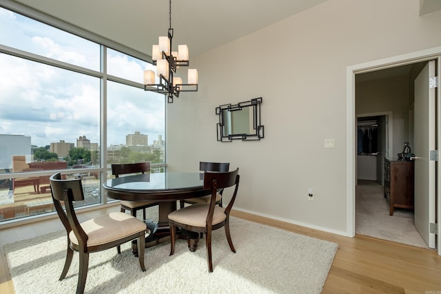 300 Third Unit 708, Little Rock, AR 72201 - dining room featuring a chandelier, light wood-type flooring, baseboards, a city view, and floor to ceiling windows