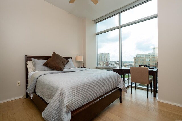300 Third Unit 708, Little Rock, AR 72201 - bedroom with floor to ceiling windows, a city view, light wood-style floors, baseboards, and ceiling fan