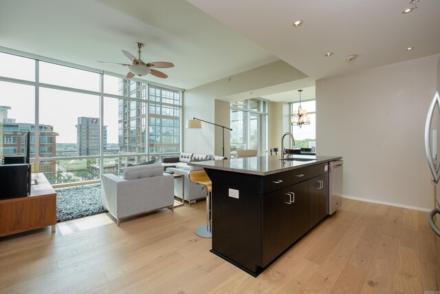 300 Third Unit 708, Little Rock, AR 72201 - kitchen with a sink, open floor plan, light wood-style floors, ceiling fan, and an island with sink