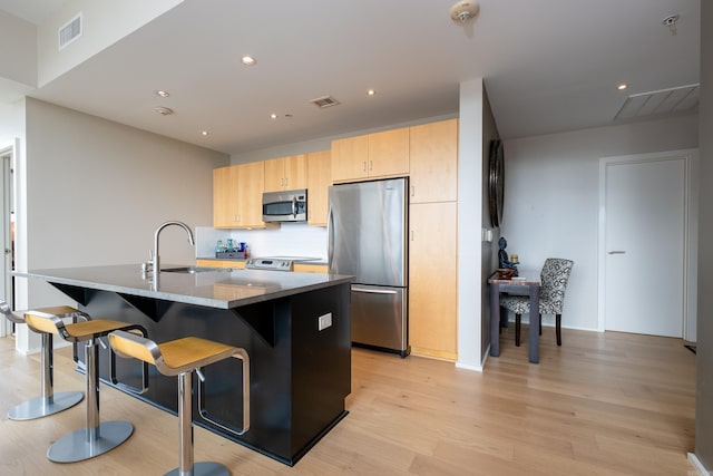 300 Third Unit 708, Little Rock, AR 72201 - kitchen featuring stainless steel appliances, a sink, light brown cabinets, light wood-type flooring, and recessed lighting