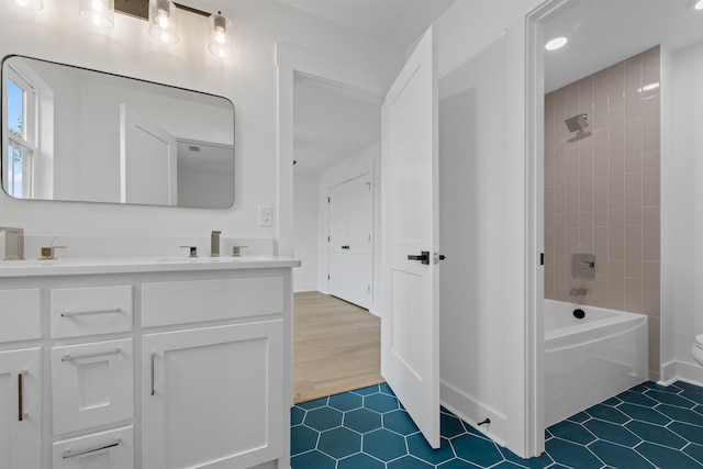 bathroom featuring tiled shower / bath, vanity, and tile patterned flooring