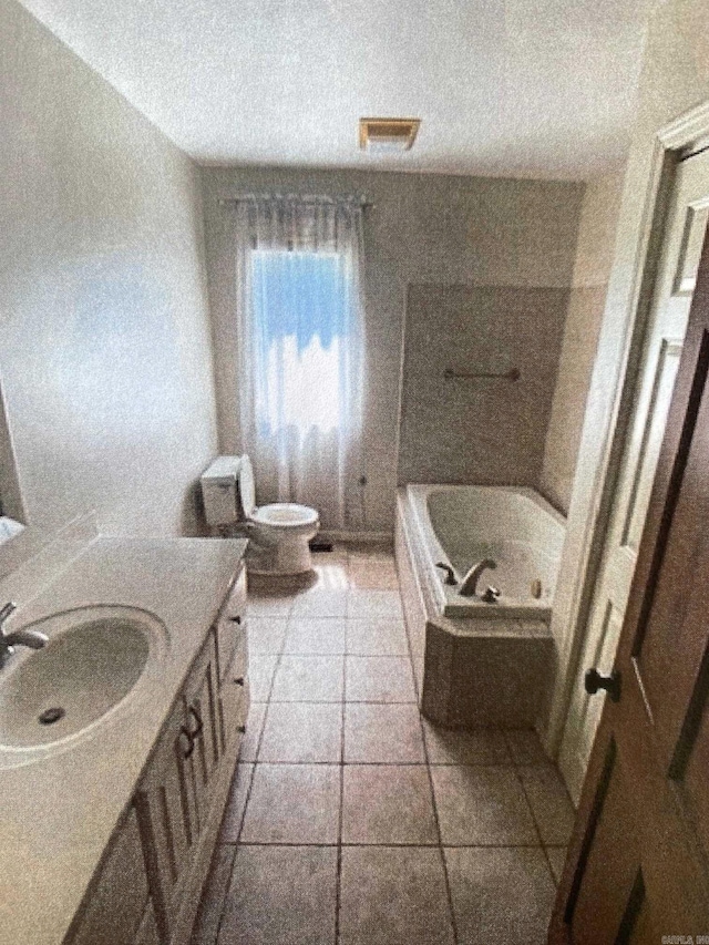 bathroom with vanity, toilet, and a tub