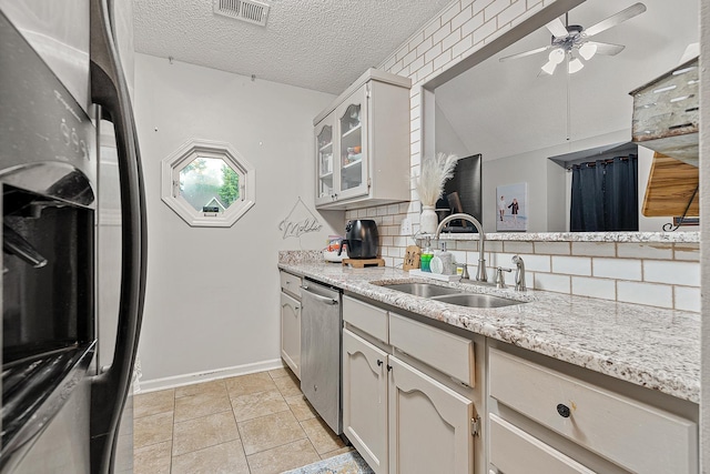 kitchen featuring sink, appliances with stainless steel finishes, tasteful backsplash, white cabinets, and a textured ceiling