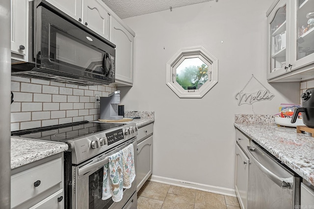 kitchen with tasteful backsplash, a textured ceiling, stainless steel appliances, and white cabinets