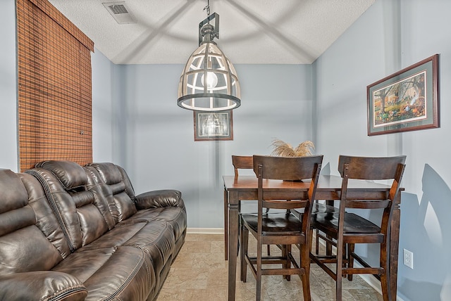 dining room with a chandelier and a textured ceiling