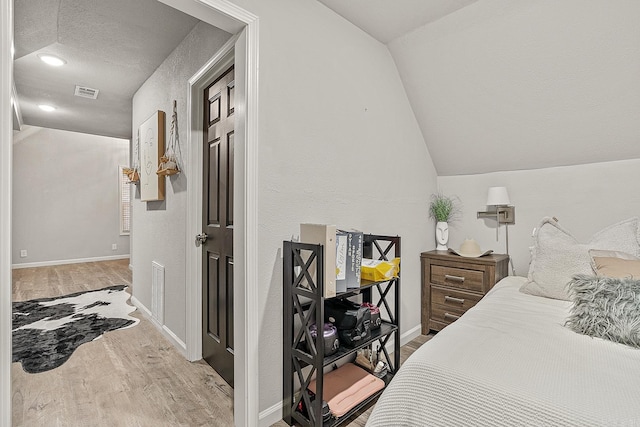 bedroom featuring lofted ceiling and light wood-type flooring