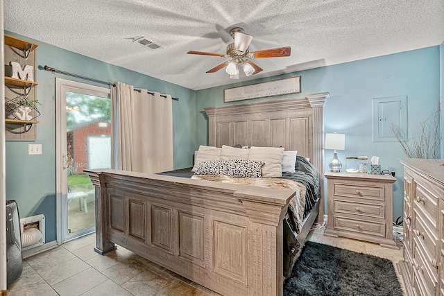 bedroom featuring ceiling fan, access to exterior, and a textured ceiling