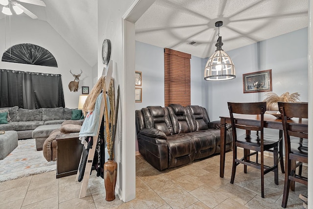 living room featuring vaulted ceiling, ceiling fan, and a textured ceiling