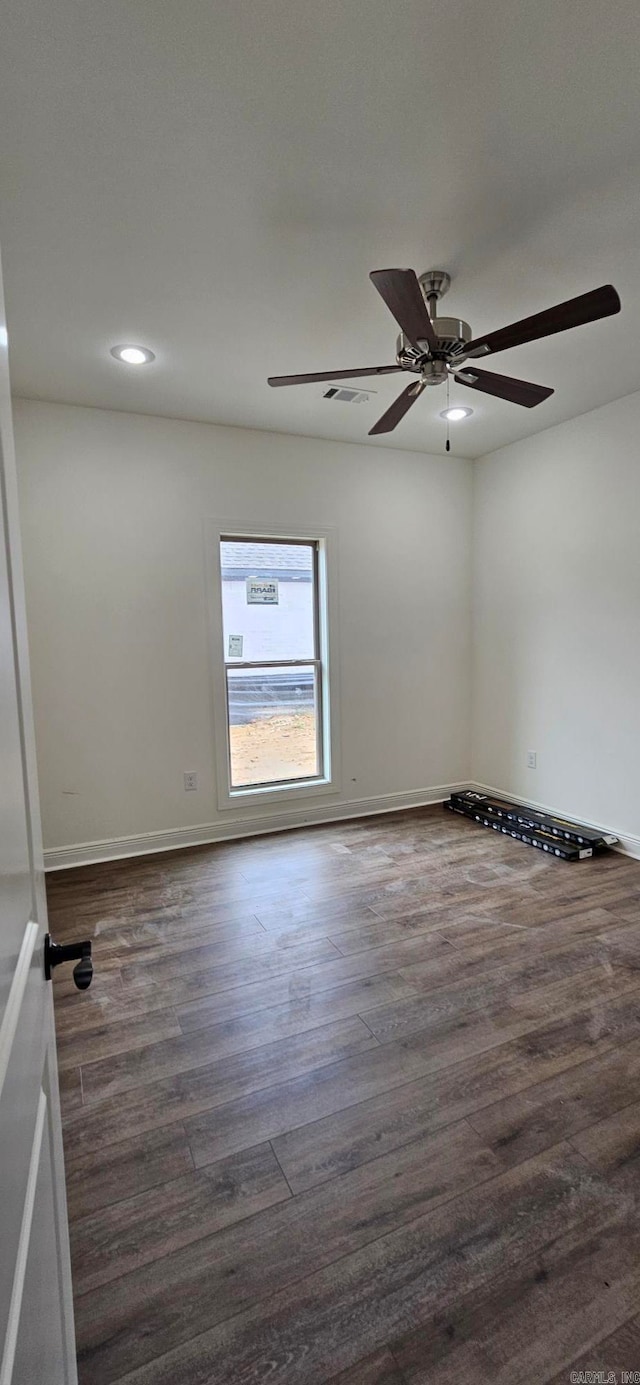 spare room featuring dark hardwood / wood-style flooring and ceiling fan