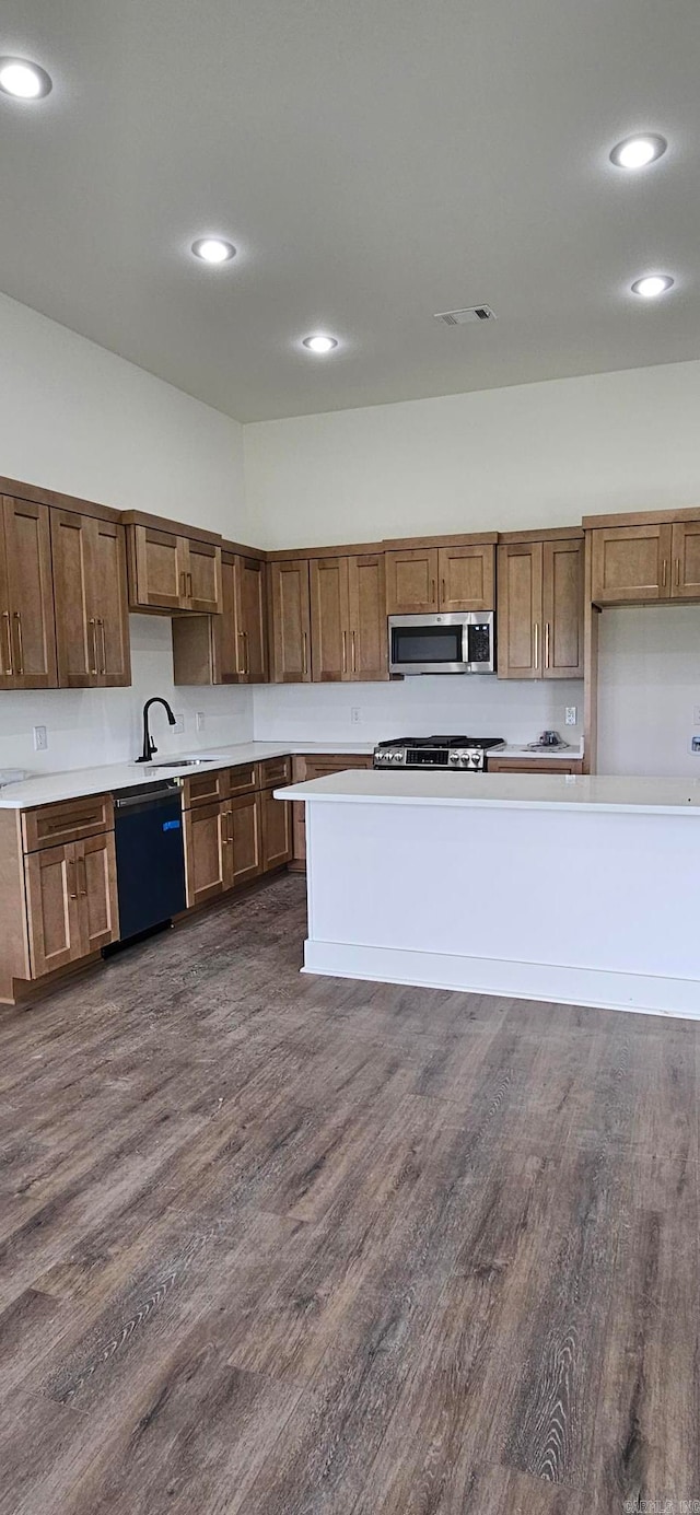 kitchen featuring stainless steel appliances, sink, and dark hardwood / wood-style flooring