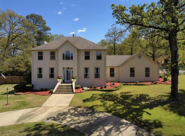 colonial inspired home with a front lawn