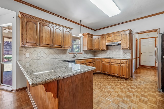 kitchen with pendant lighting, light stone countertops, ornamental molding, kitchen peninsula, and light parquet flooring