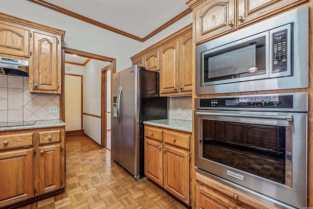 kitchen featuring stainless steel appliances, crown molding, light stone counters, light parquet flooring, and exhaust hood