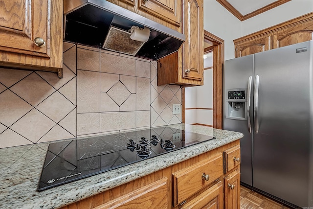 kitchen with backsplash, crown molding, exhaust hood, stainless steel refrigerator with ice dispenser, and black electric cooktop