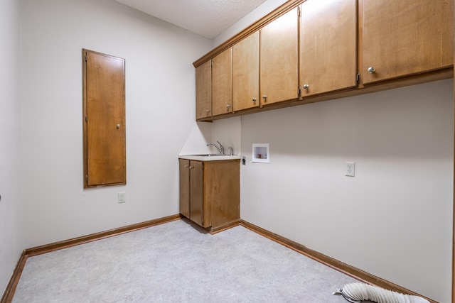 clothes washing area featuring cabinets, washer hookup, and sink