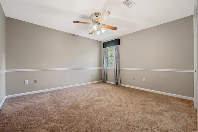 empty room featuring ceiling fan and carpet