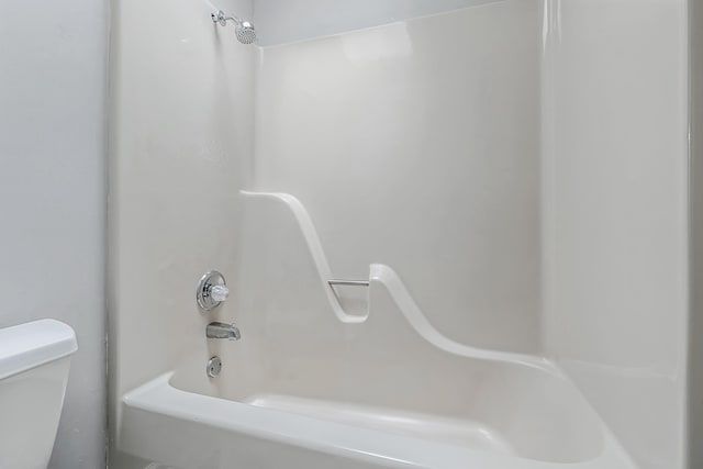 bathroom featuring shower / bathtub combination and toilet