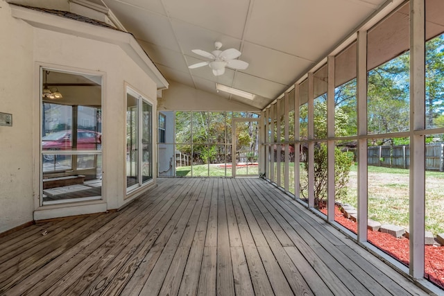 unfurnished sunroom featuring ceiling fan, plenty of natural light, and vaulted ceiling