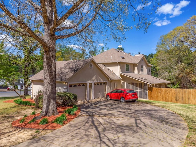 view of property with a garage and a sunroom