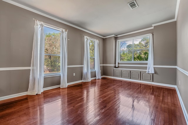 spare room featuring a wealth of natural light, wood-type flooring, and ornamental molding