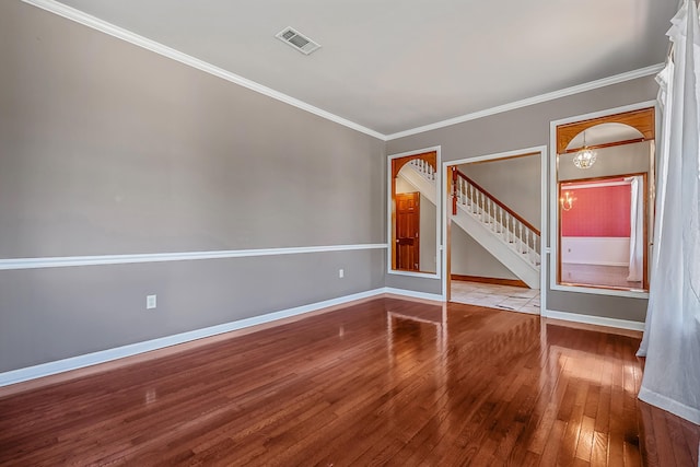 unfurnished room with ornamental molding, a notable chandelier, and light wood-type flooring