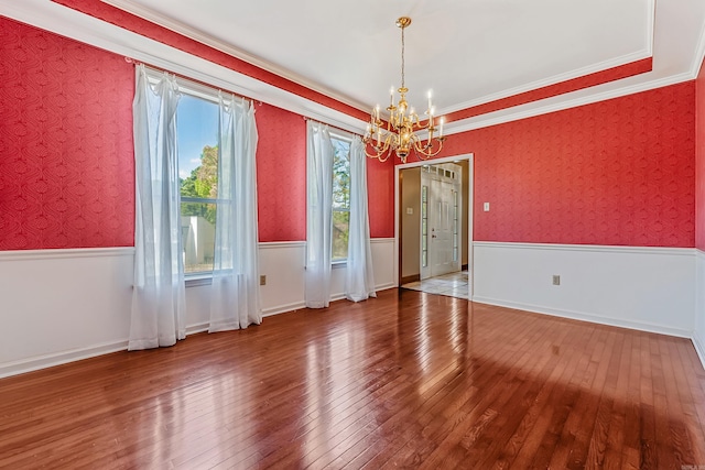 unfurnished dining area featuring crown molding, hardwood / wood-style flooring, and a chandelier