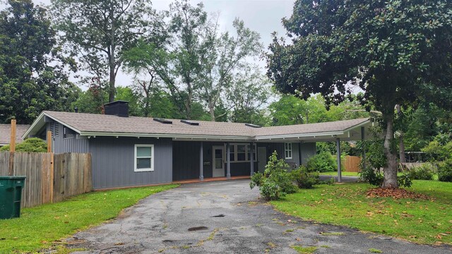 single story home featuring a carport and a front yard