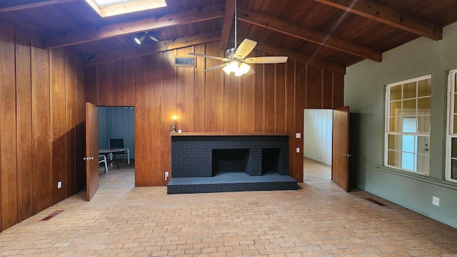 unfurnished living room featuring a skylight, beam ceiling, wood ceiling, and ceiling fan