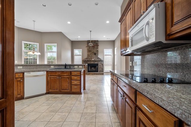 kitchen with sink, white appliances, decorative light fixtures, and light tile patterned floors