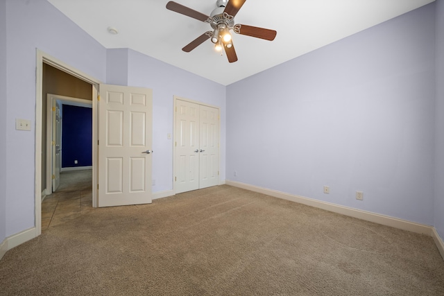 unfurnished bedroom with vaulted ceiling, carpet flooring, ceiling fan, and a closet