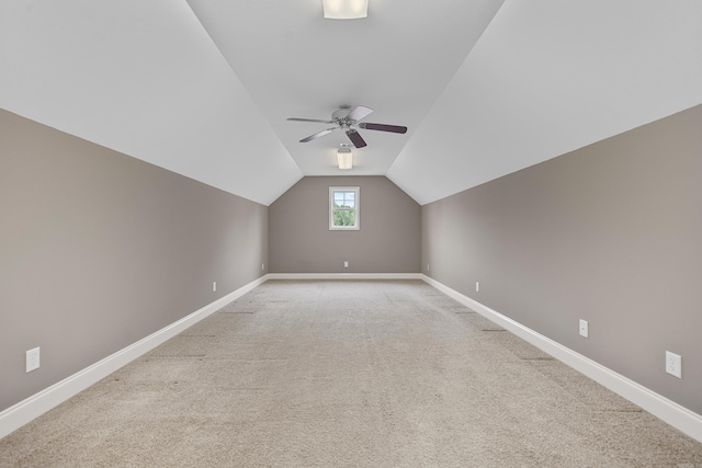 additional living space featuring vaulted ceiling, light carpet, and ceiling fan