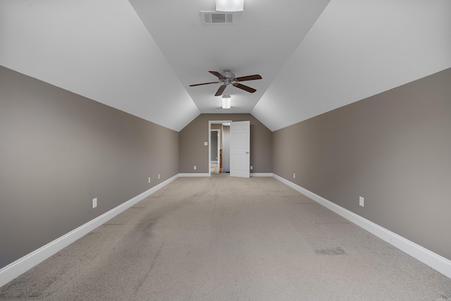 additional living space with ceiling fan, vaulted ceiling, and light carpet