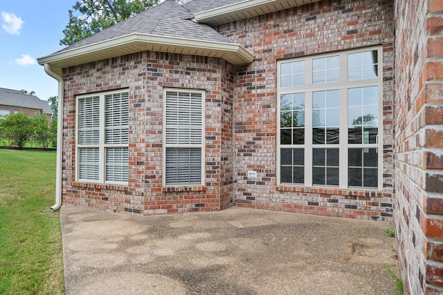 entrance to property with a yard and a patio