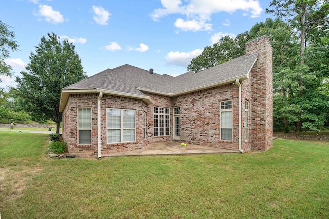 rear view of property with a patio and a lawn