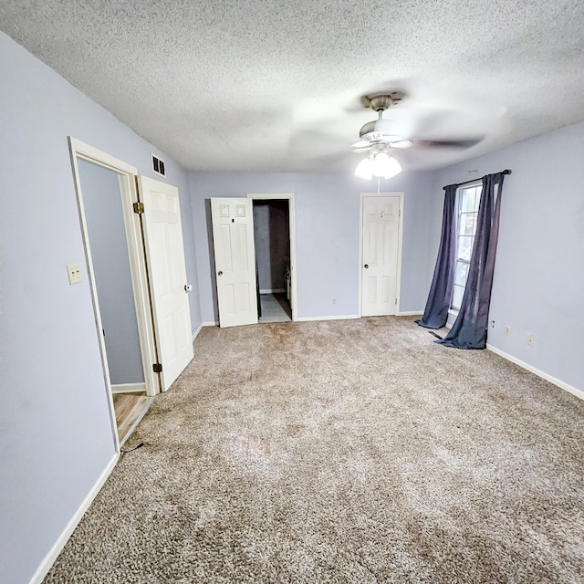 unfurnished bedroom with a textured ceiling, carpet floors, and ceiling fan