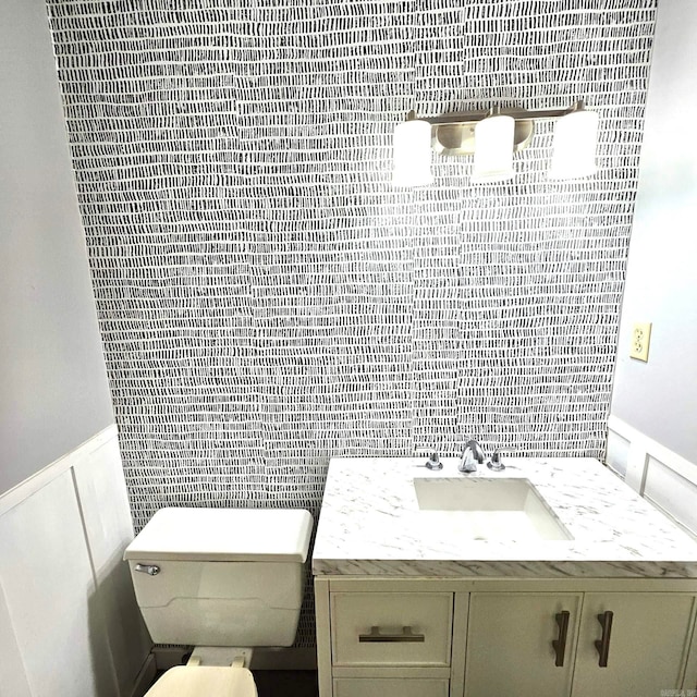 bathroom featuring tile walls, toilet, and vanity