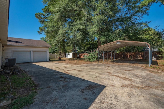 view of yard featuring a garage, a carport, cooling unit, and a storage unit