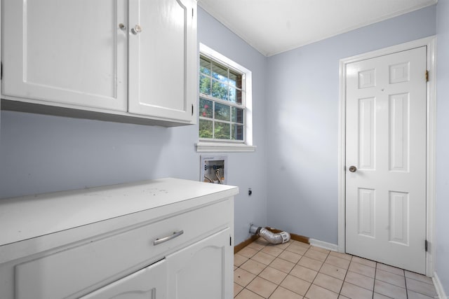 clothes washing area featuring hookup for an electric dryer, light tile patterned floors, washer hookup, and cabinets