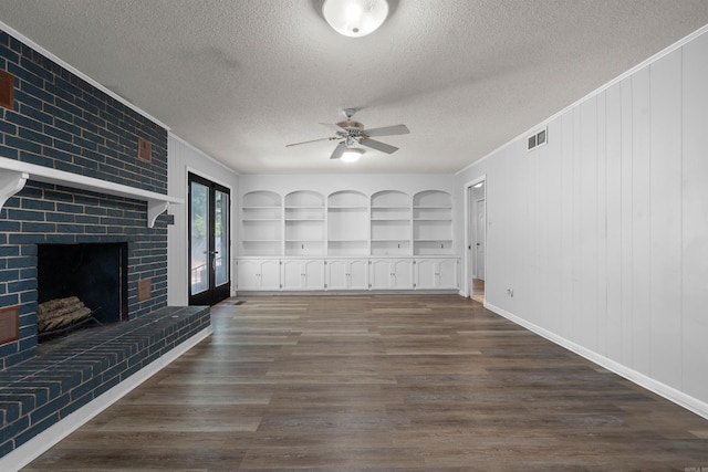 unfurnished living room featuring a textured ceiling, dark hardwood / wood-style floors, and brick wall