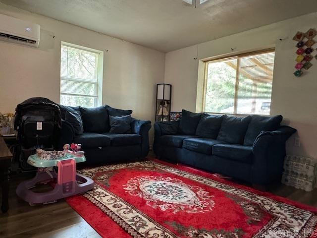 living room featuring a wall unit AC, a wealth of natural light, and wood-type flooring