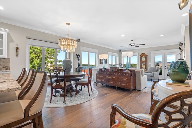 dining room with crown molding, dark hardwood / wood-style flooring, and ceiling fan with notable chandelier