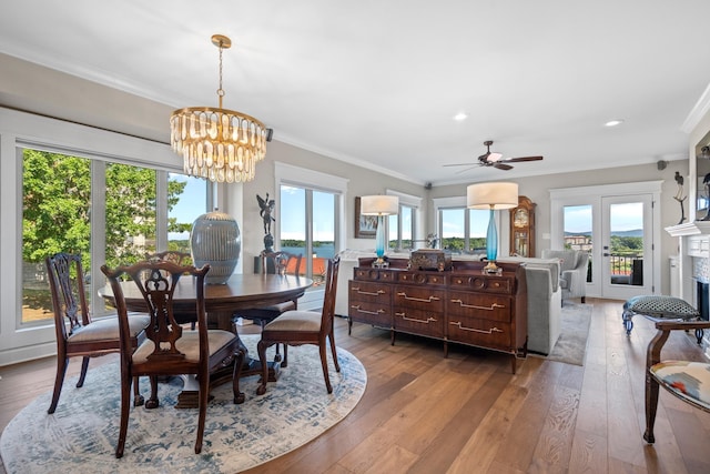 dining area with crown molding, ceiling fan with notable chandelier, and light hardwood / wood-style flooring