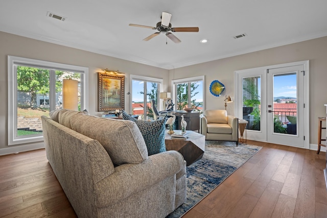 living room featuring crown molding, ceiling fan, and light wood-type flooring