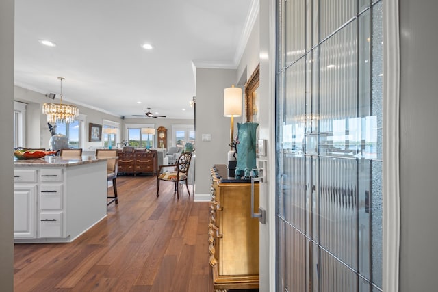 interior space featuring dark wood-type flooring, ornamental molding, and a chandelier