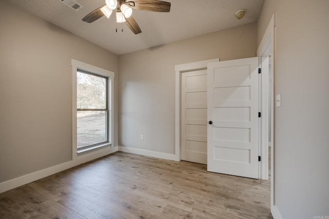 unfurnished bedroom with ceiling fan, a textured ceiling, and light hardwood / wood-style floors