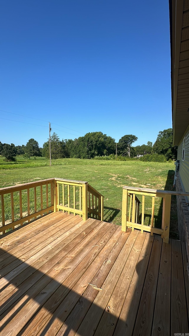 deck featuring a yard and a rural view