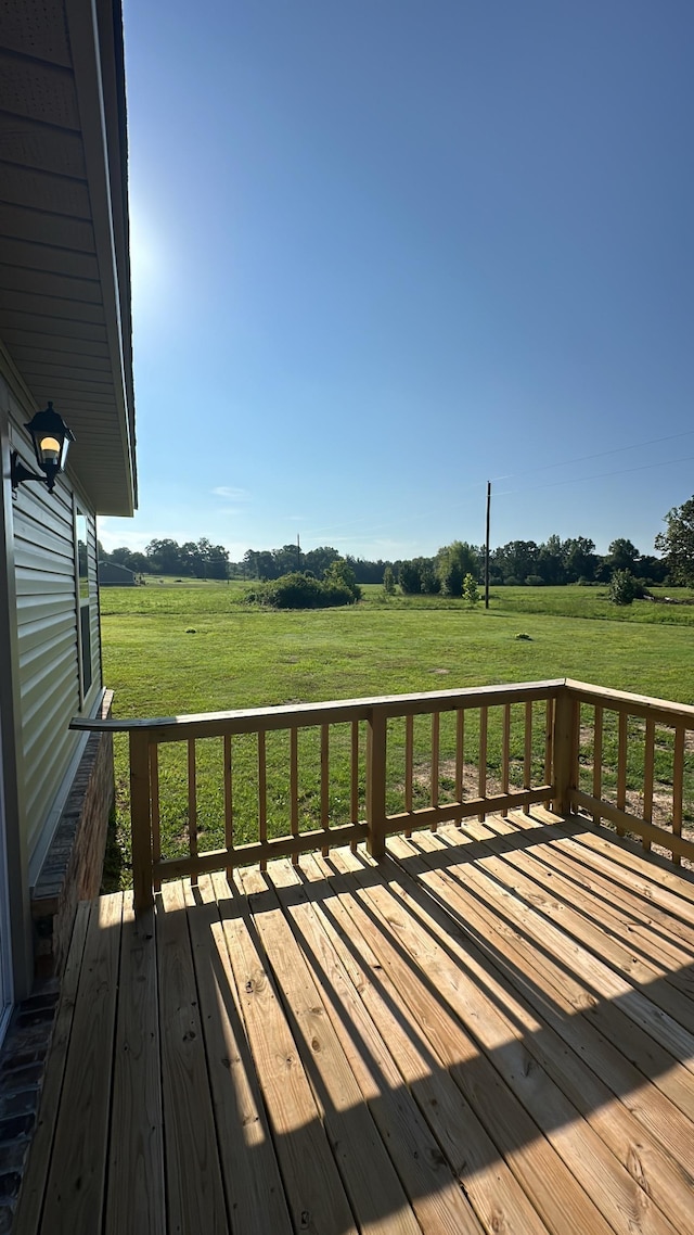 wooden deck with a yard and a rural view