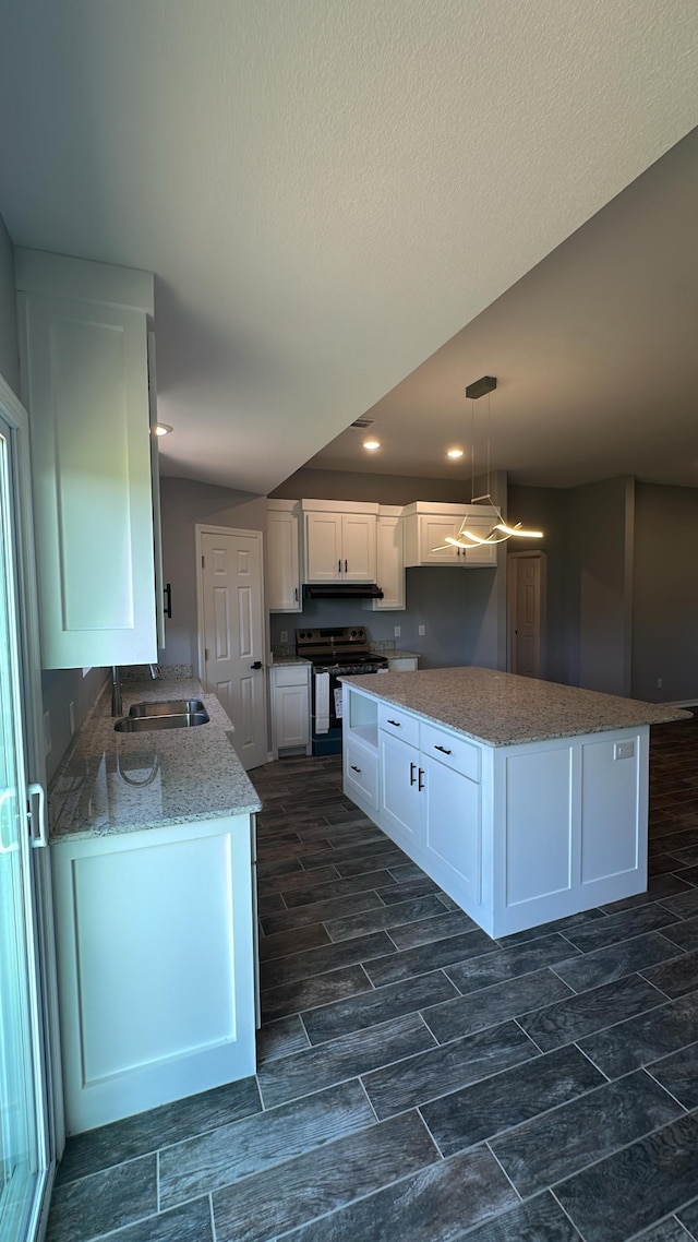 kitchen featuring sink, white cabinetry, hanging light fixtures, range with electric cooktop, and light stone counters