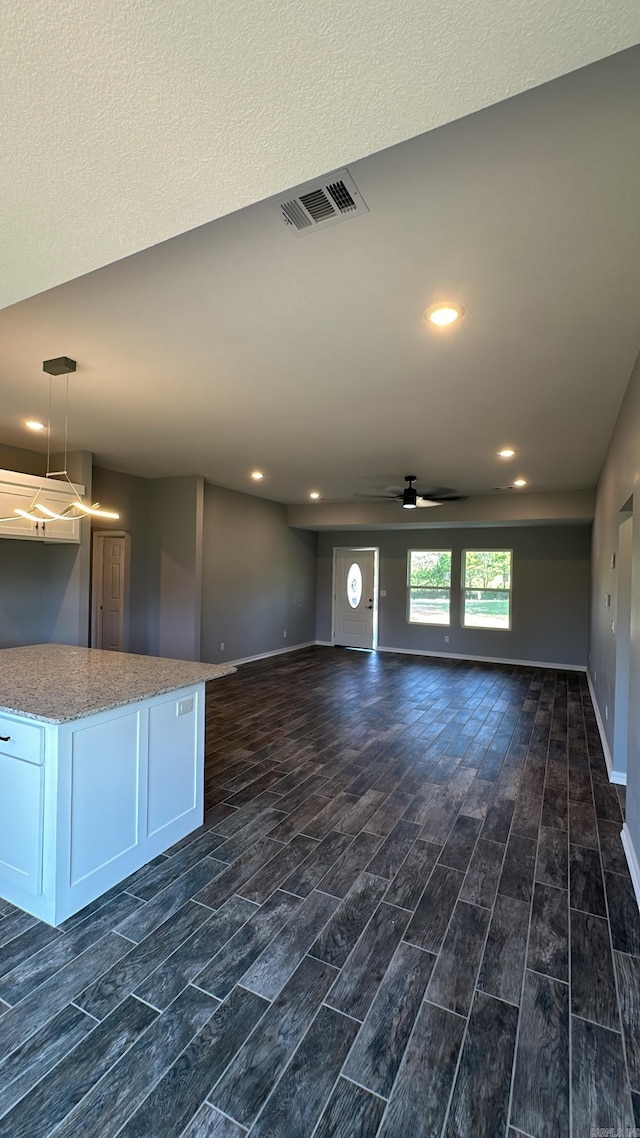 unfurnished living room with ceiling fan